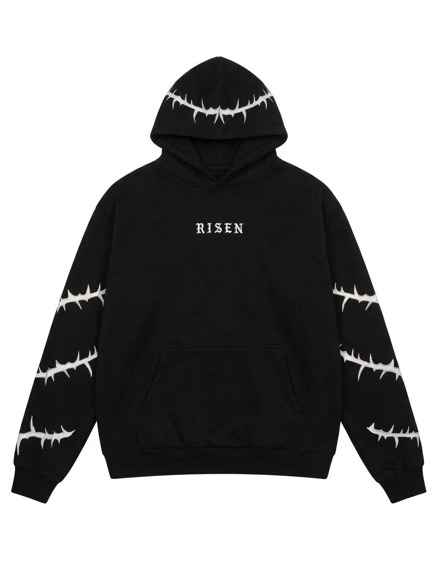 A black pullover hoodie with white barbed wire patterns printed on the hood, sleeves, and cuffs, featuring the word 'RISEN' in white gothic font on the chest.